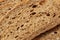 Texture of slice dark rye bread with seeds and bran, background