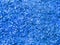 Texture of small sawdust in blue color. Artistic object. Designer material.