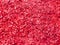 Texture of small sawdust in red color. Artistic object. Designer material.