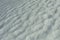 Texture of snow. Snow melts in spring. Waves on surface. Natural background is winter