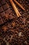 Texture spilling coffee beans, chocolate, cinnamon and cloves. Top view. Copy space