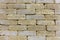 The texture of the stone wall of the old brick, building stone of beige-golden sandstone