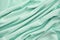 Texture of synthetic green fabric with decorative a pleats