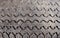 Texture of thick-skinned rubber tire colored in dark gray with carved pattern