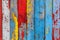 Texture of vintage wood boards with cracked paint of white, red, yellow and blue color, with copy space. AI generated image.