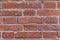 Texture of a wall of aged red brick closeup