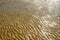 Texture of wet sea sand with patterns of water.