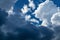 Texture of white and gray thunderclouds on a blue sky in sunlight, abstract natural background.