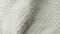 Texture of white textile, close shot. Camera slowly sliding along white fabric. Pattern on textile, abstract background