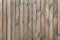The texture of a wooden fence made of unpainted wood, weathered, nailed down with rusted nails. A high resolution
