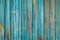 Texture of wooden planks with peeling turquoise blue color paint