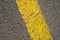 Texture of a worn yellow line on an asphalt road