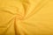 Texture of yellow cotton wrinkled fabric, background or backdrop. Clothing, sewing, gressmaking, haberdashery.