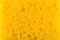 Texture yellow foam rubber, synthetic sponge with large pores, close-up background