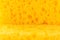 Texture yellow foam rubber, synthetic sponge with large pores, close-up background