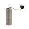 Textured aluminum manual coffee grinder on white background close up