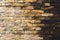 Textured background of old faded bricks stained with black oil. A brick gradient between dirty black and light yellow