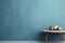 Textured dusty blue painted wall copy space. Monochrome empty room with minimalist wood table. Wall scene mockup product for