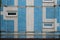 Textured facade of a panel apartment building of a Soviet house lined with blue tiles, close up of wall
