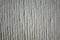 Textured of plaster base layer for decorating. Vertical stripes with groove of pale grayish tint