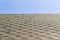 Textured roof of building with shingle covering against clear blue sky. Copyspace