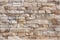 Textured stone wall brick with a seamless pattern of sandstone facade.