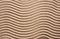 Textured wavy sand. The waves on the sand in the form of a zigzag. Top view. Place for text