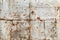 Textured white metal wall exhibits rustic beauty with rust stains