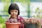 Thai Asian girl, age 4 to 6 years old, beautiful and cute. She was gently checking and checking the growth of the Callisia Repens