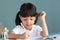 Thai Asian kid girls, aged 4 to 6 years old, look cute and bright. Healthy Sitting in the house studying She is writing a book and
