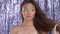 Thai asian model in studio with silver rain disco background and party makeup