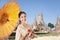 Thai asian women welcome with traditional Thai suit and umbrella on temple background