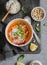 Thai carrot sweet potato soup with rice on the dark table, top view.