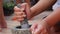 Thai chilli and garlic pounding in stone mortar with pestle. Woman preparing sauce for thai soup tom yam. Close Up. 4k