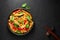 Thai Drunken Noodles or Pad Kee Mao in white plate at black slate background. Drunken Noodles is thai cuisine dish