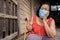 Thai elderly woman in round-necked sleeveless collar wearing medical mask for protect corona virus covid-19 pandemic in wooden
