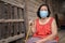 Thai elderly woman in round-necked sleeveless collar wearing medical mask for protect corona virus covid-19 pandemic in wooden