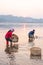 Thai farmer washing Bean Sprouts in Mekong River at sunrise. Bean Sprouts in bamboo basket. Organic vegetables. Thai-Laos border