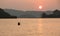 Thai fisherman setting fishing nets before low tide at sunset