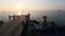 Thai fishing boat and wooden catwalk on the sea coast during sunset. Travel.