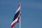 Thai flag waves into blue sky