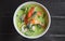 Thai food. Seafood green curry soup on dark wooden background