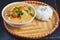 Thai food vertical background concept. Dish of Thailand cuisine. Tom yum pork soup in black dish, rice in wooden plate, wooden