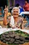 Thai granny with big welcome smile in local market selling Thai