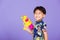 Thai kid funny hold toy water pistol and smiling