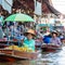 Thai locals sell food and souvenirs at famous Damnoen Saduak floating market, Thailand