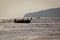 Thai long-tail boat arriving on shore in backlit