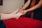 Thai man making classical feet thai massage procedure to young woman at beauty spa