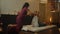 Thai massage salon. Asian woman in traditional clothes doing therapeutic relaxing massage, Caucasian woman. Professional