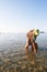 Thai muslim women with pipe in search of a hard-shell clam in the coastline of Trang Province, Thailand. Summer season